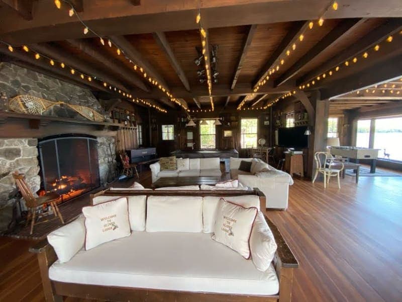 A cozy living room featuring a stone fireplace, comfortable sofas, and warm lighting.